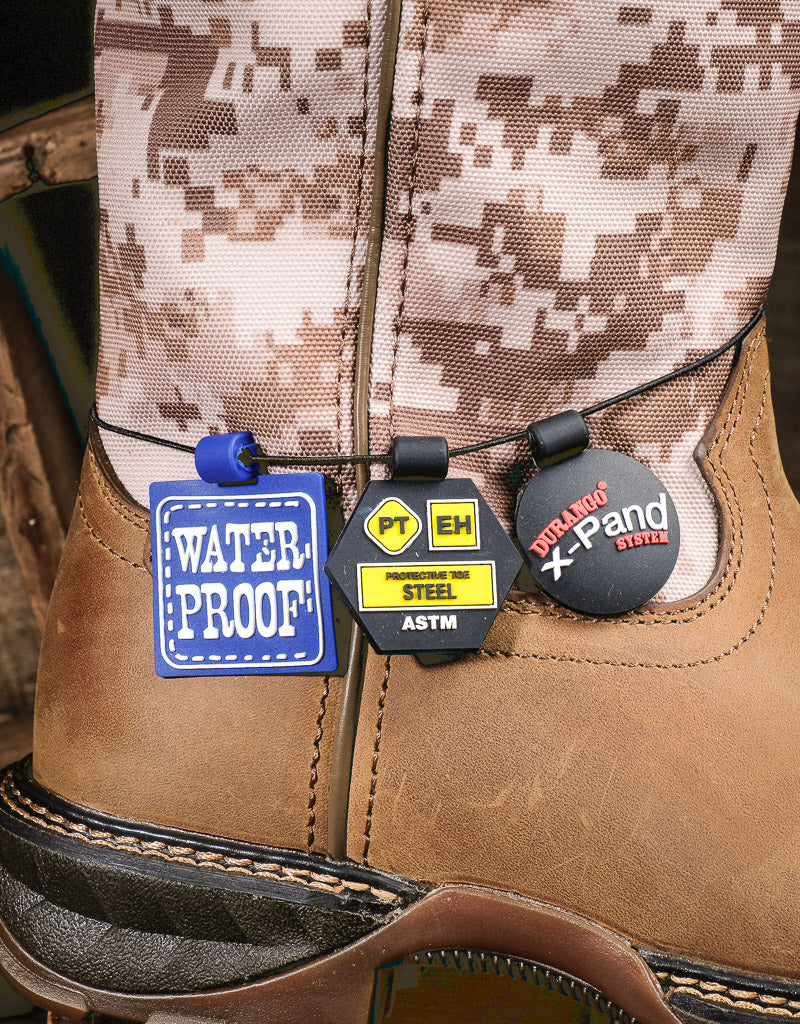 feature tags laying on top of boot. A waterproof label, steel toe and EH rated label and Durango X-pand system tag