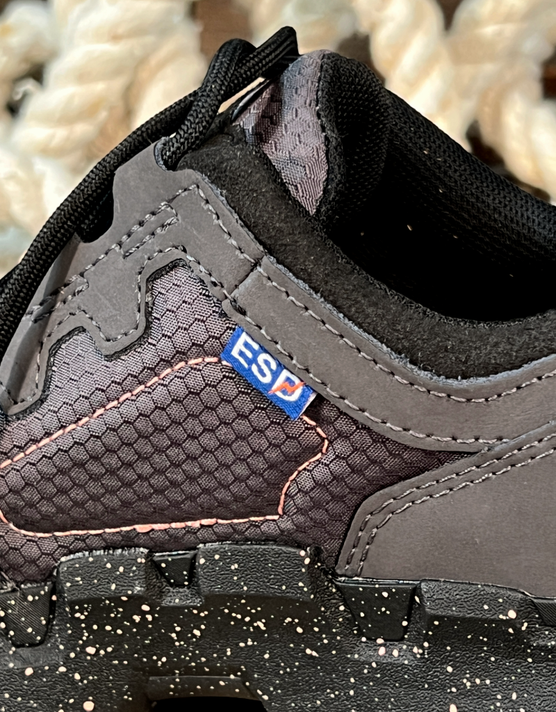 Close-up of a gray shoe with a visible ESD logo on a textured background
