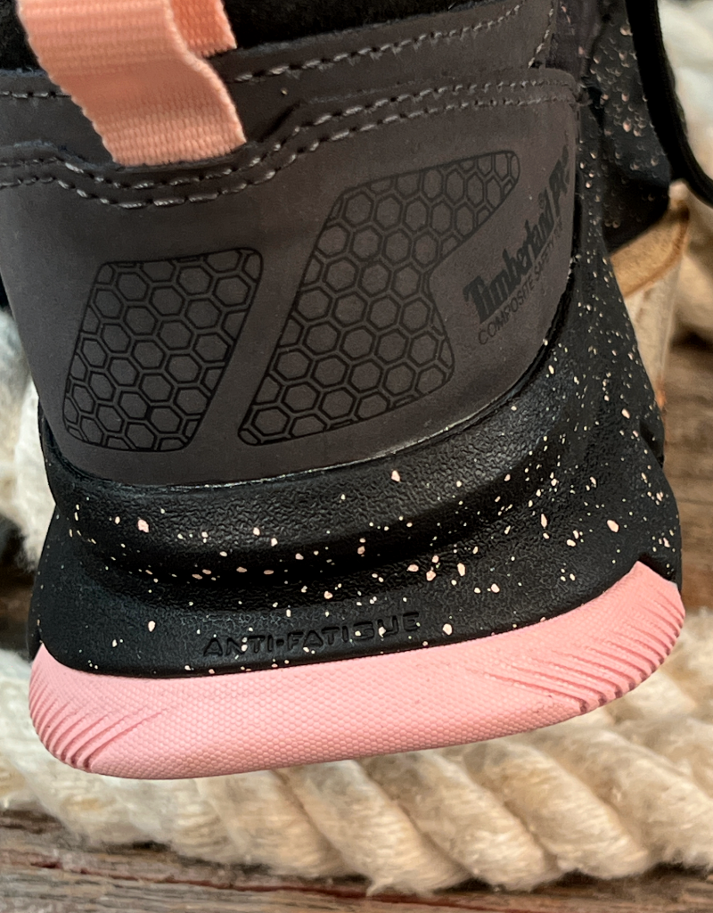 Close-up of a grey sneaker with a black and pink sole on a wooden floor.