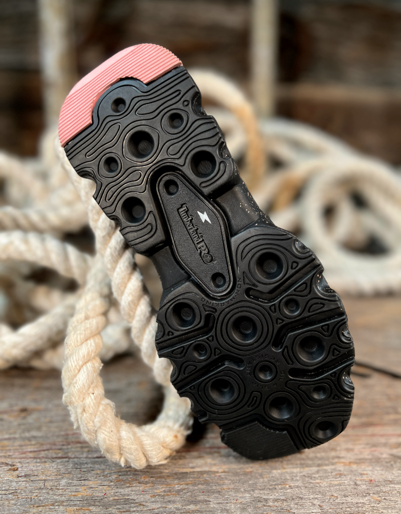 Close-up of a black shoe sole with pink heel on a wooden surface with rope.