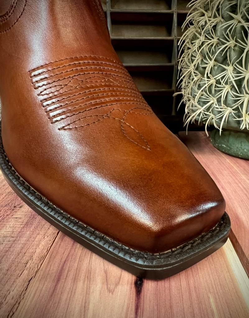 Brown leather boot with detailed stitching on a wooden surface