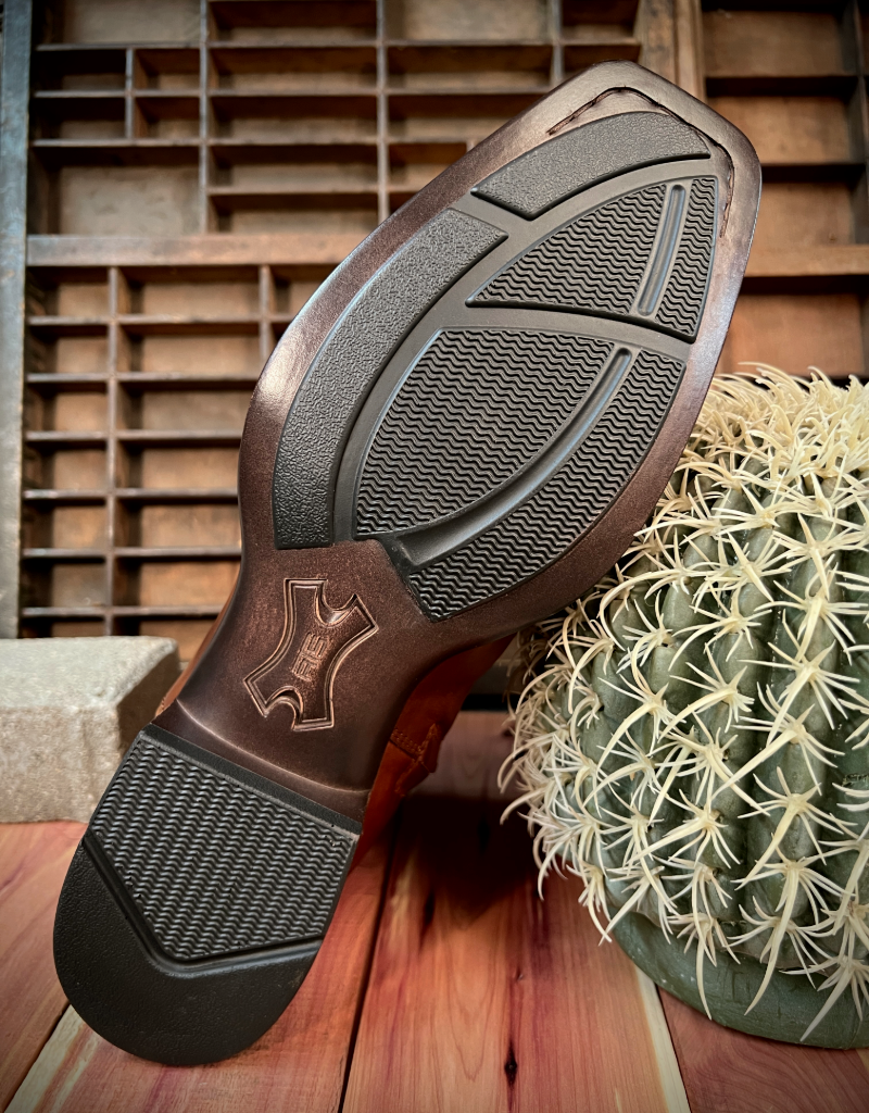 Close-up of Ariat Bantamweight boot sole with tread pattern on a wooden surface with a cactus.