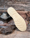Cream wedge sole on a wooden background with rustic tools.