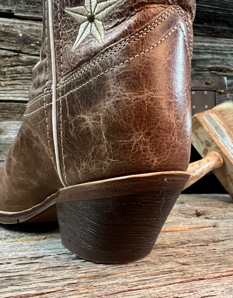 Close-up of a brown leather boot with a star design on a wooden surface