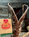 Brown cowboy boot with star patterns and a brand tag that says Wide Calf Deep dip shaft on a wooden surface