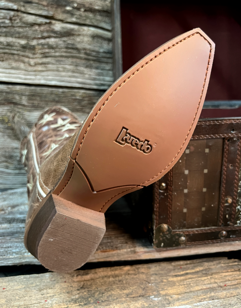 Close-up of a brown leather boot sole with 'Laredo' branding, against a rustic wooden background.