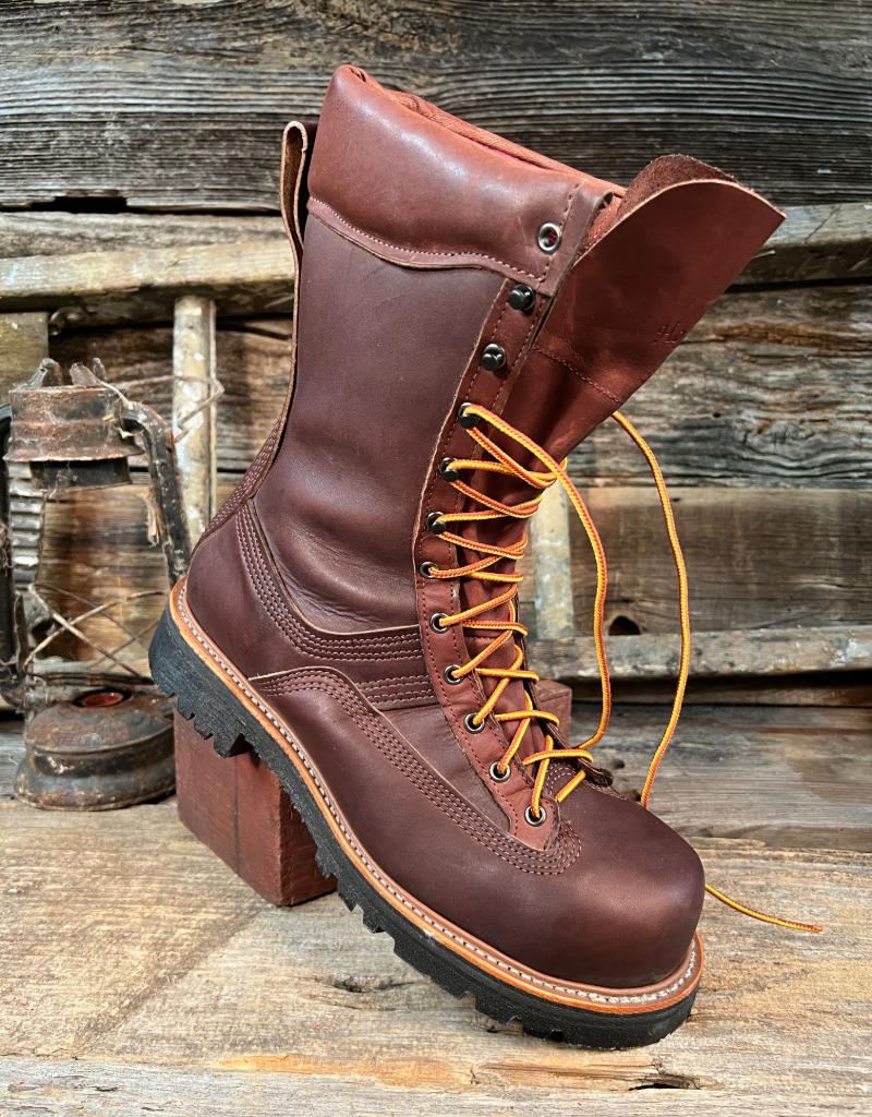 Brown leather boot with orange laces on a wooden background