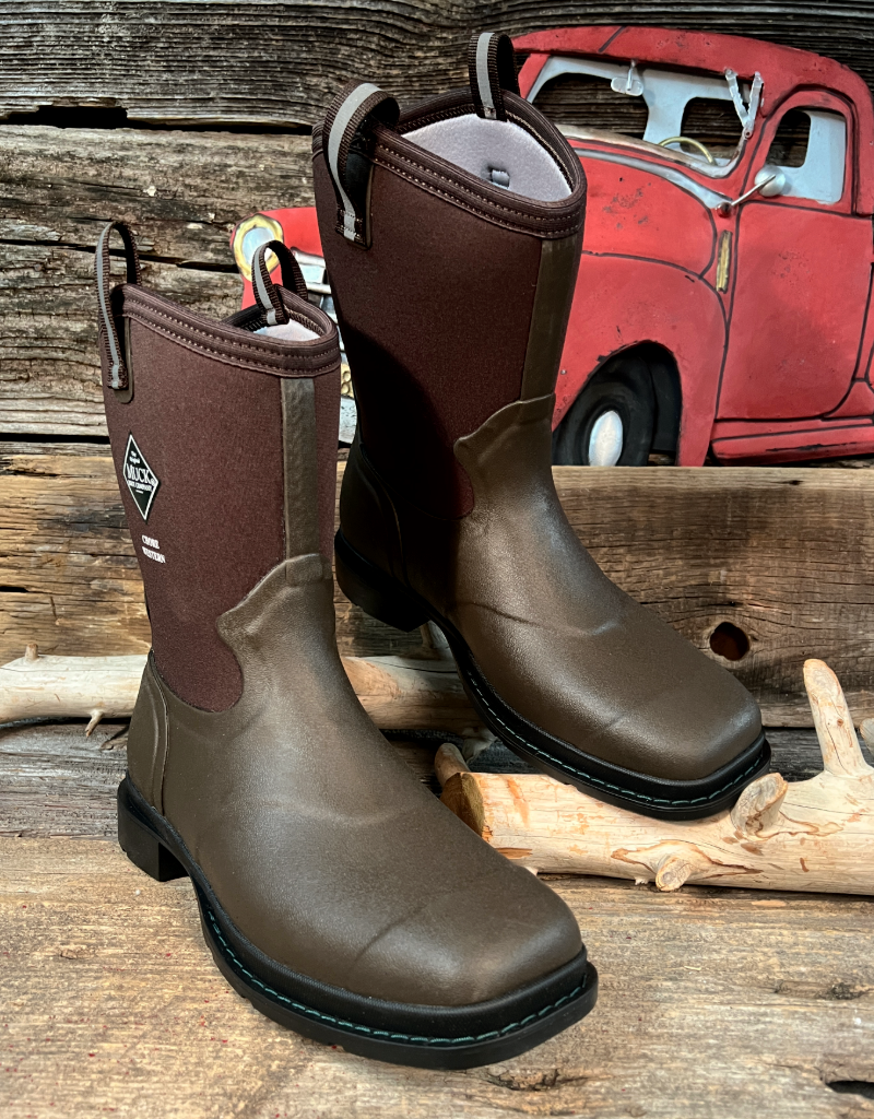 Brown rubber boots on a wooden surface with a red truck in the background