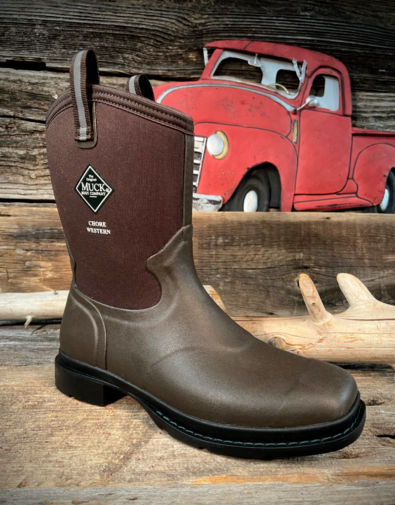 Brown Muck boot on a wooden surface with a red vintage truck in the background