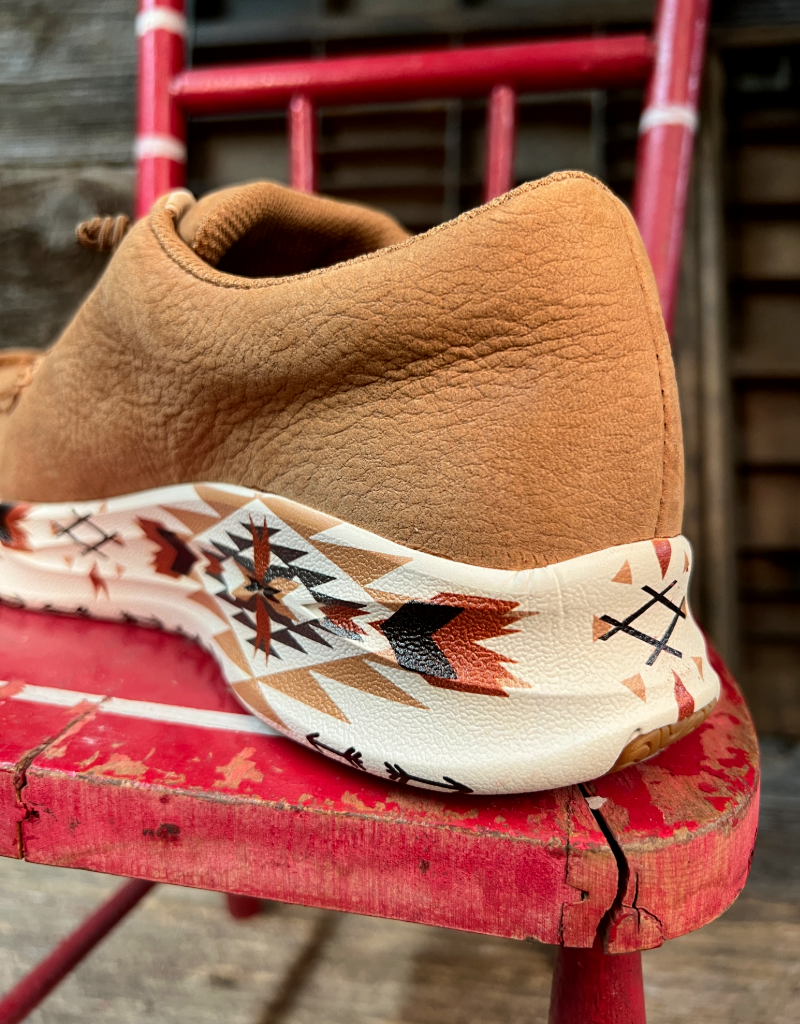 heel closeup on brown leather shoe with patterned sole on a red chair