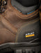 Close-up of a brown work boot with Ariat branding, featuring steel toe and waterproof labels.