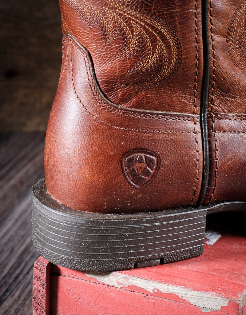 Heel of brown western boot with Ariat symbol on the leather and a rubber heel