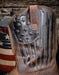 Close up of the star and stripe tooling on the leather shaf of this Ariat western boot. With a blurred wooden background
