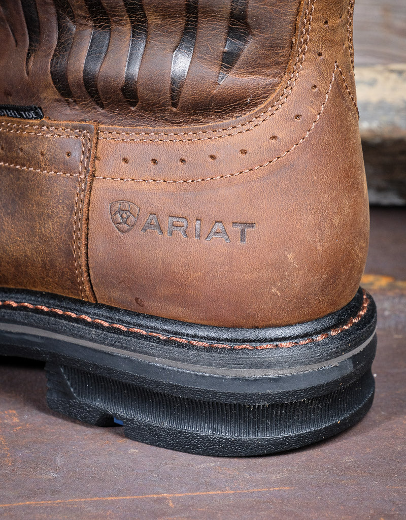 Closeup of western heel with the Ariat logo stamped into the leather. The heel is black and resting on a metal sheet