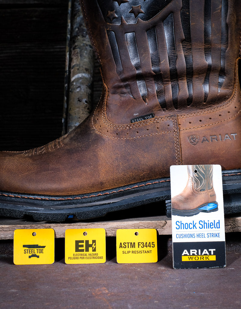 Ariat feature tags sitting in front of a leather pull on boot. They read: "Steel toe, EH Electrical Hazard pesto for electricidad, ASTM F3445 Slip Resistant, Shock Shield cushions heel strike Ariat Work"