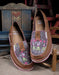 ariat aloha cruisers resting on two tiny wooden chairs. The shoes are brown with an aloha print on the toes