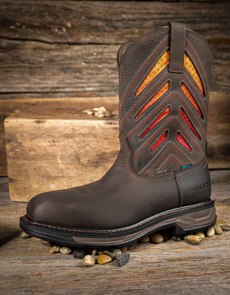 Brown work boot with orange and red vent panels on a wooden background