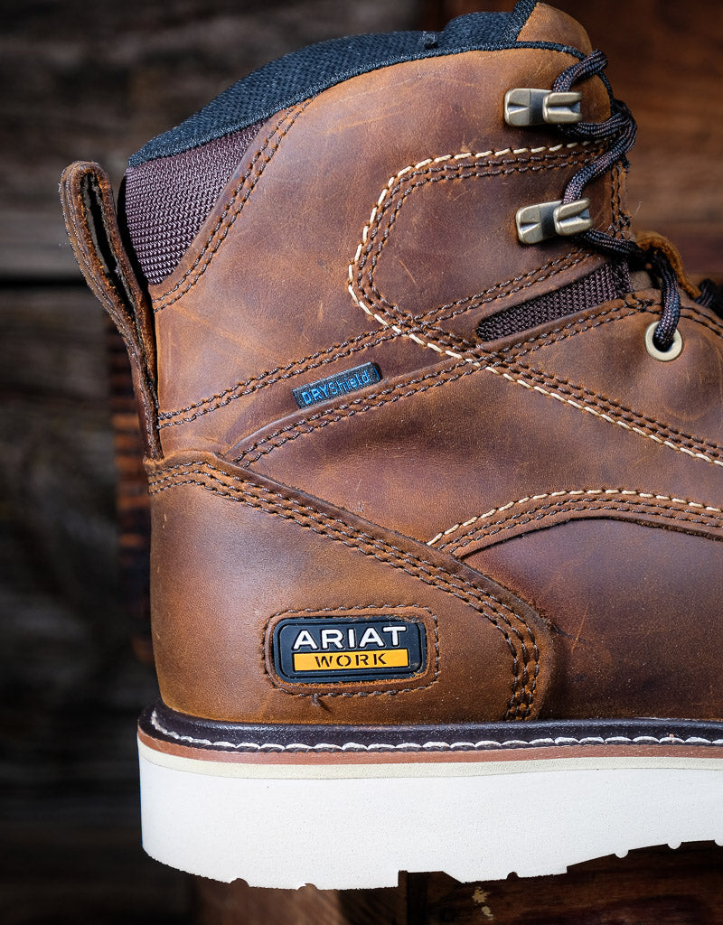 Brown leather work boot with Ariat branding on a blurred background