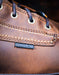 Close-up of a brown leather boot with a composite toe label.