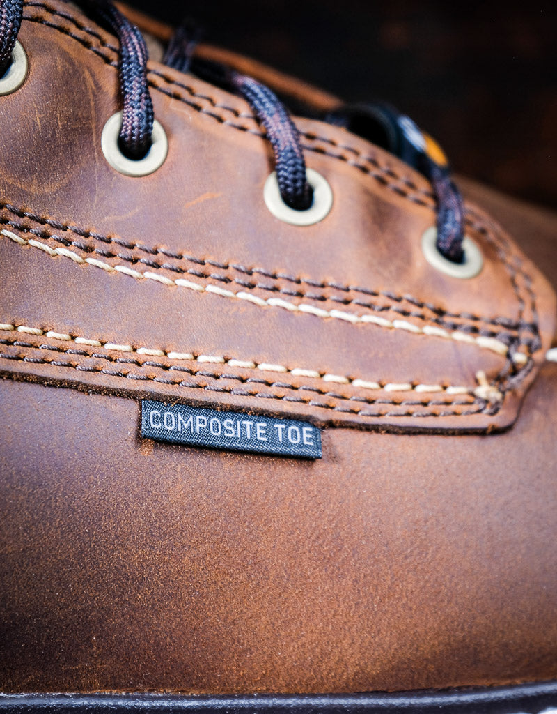 Close-up of a brown leather boot with a composite toe label.