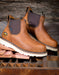 Brown leather chelsea style boots with white soles on a wooden surface