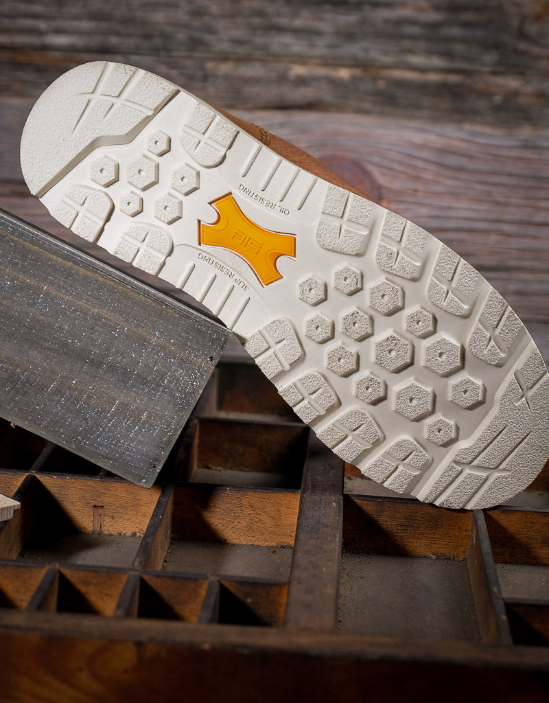 Close-up of a shoe sole with a brand logo on a wooden background
