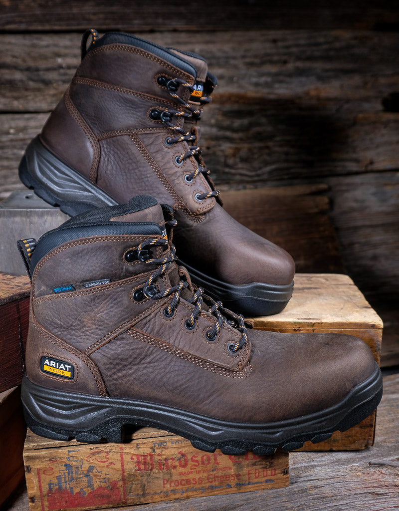 Brown work boots on a wooden pallet with a rustic background
