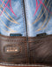 Close-up of Ariat work boots with blue embroidered design,  'Steel Toe' label and DryShield label.
