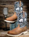 Brown work boots with decorative inlays on a wooden background