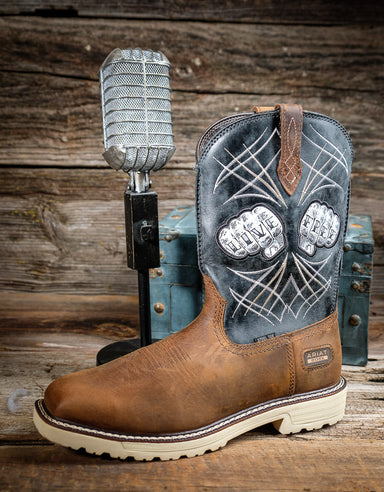 Brown cowboy boot with decorative top next to a microphone on a wooden background