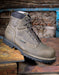 Grey work boot with laces on a rustic wooden background