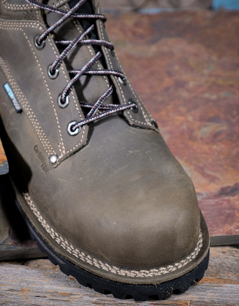Grey leather boot with laces on a rustic wooden surface