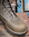 Grey leather boot with laces on a rustic background