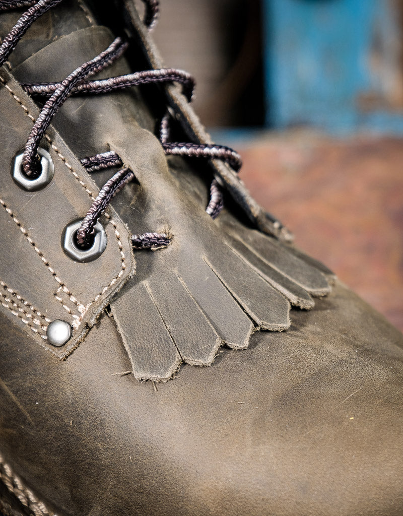 Close-up of a grey leather boot with detailed stitching and laces.