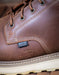 Brown leather boot with waterproof label and "Non-metallic Toe" imprinted on the leather on a wooden surface
