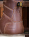 Brown leather boot with 'Carolina' branding and 'EH' label on a blurred background