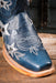 Blue cowboy boot with star patterns on a wooden surface