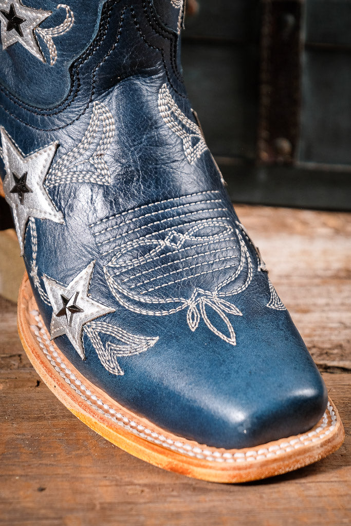 Blue cowboy boot with star patterns on a wooden surface