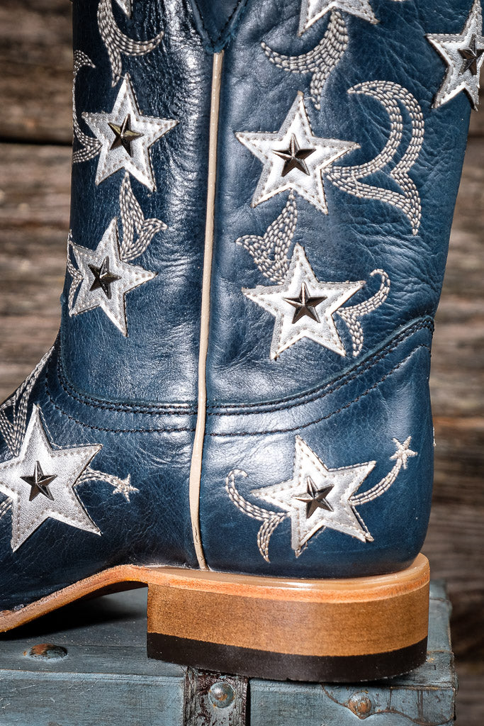 Blue cowboy boot with star patterns on a wooden surface
