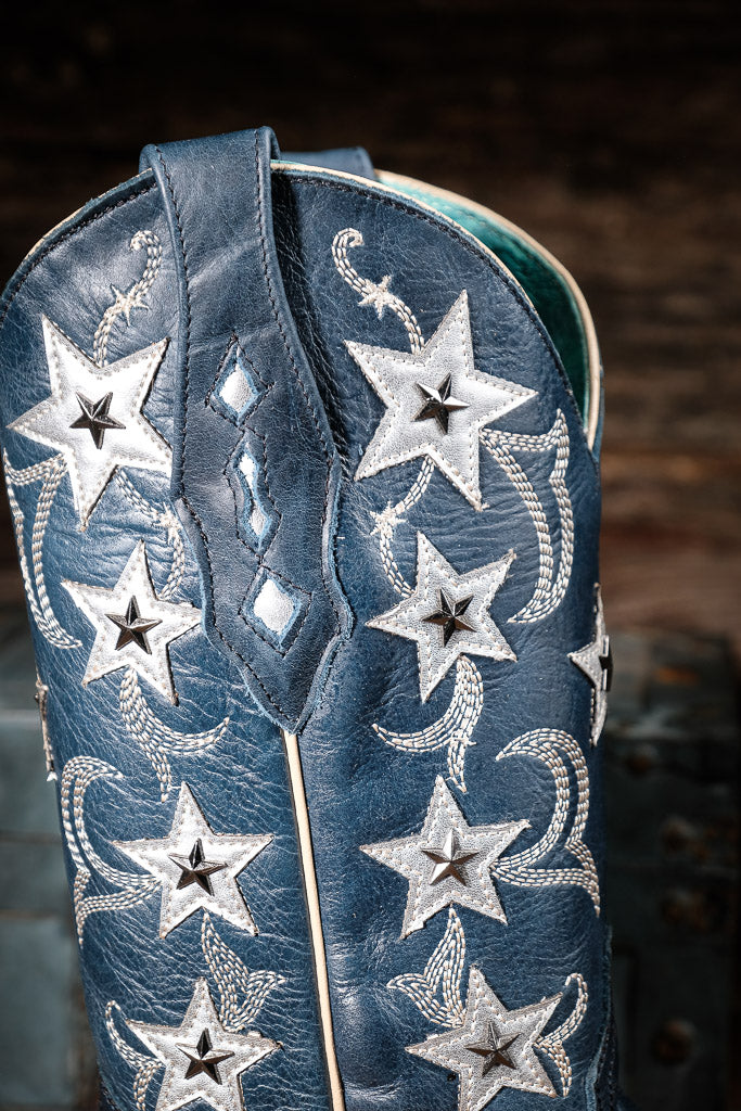 Blue cowboy boot with silver star and moon designs on a dark background