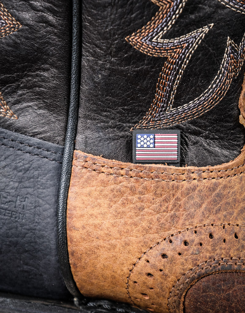 Close-up of a leather boot with intricate stitching and an American flag patch.