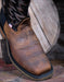 Brown leather boot with black welt on a wooden surface