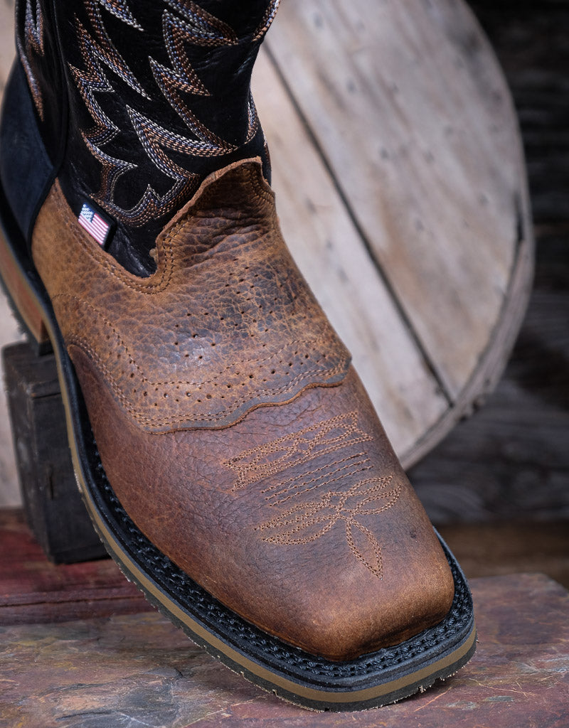 Brown leather boot with black welt on a wooden surface