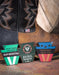 Close-up of a pair of brown cowboy boots with visible 'slip resisting, american bison and union built' labels on a wooden surface.