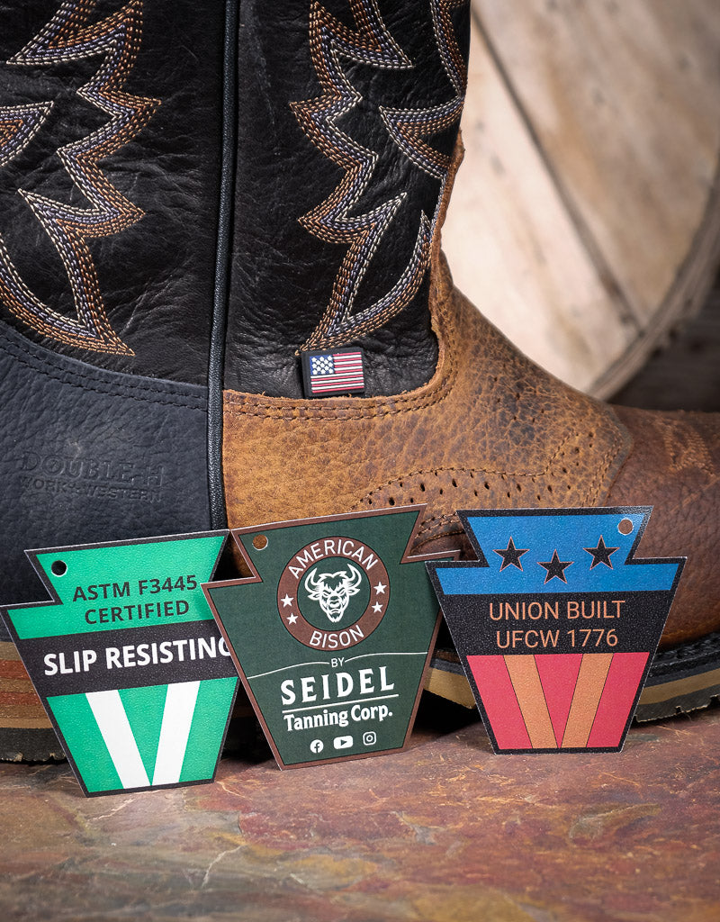 Close-up of a pair of brown cowboy boots with visible 'slip resisting, american bison and union built' labels on a wooden surface.