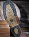 Close-up of a shoe sole with 'Trust in L.C.E.' text on a wooden surface.