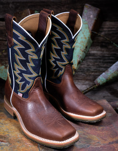 Pair of brown and dark blue cowboy boots with western stitching on a rustic wooden surface.