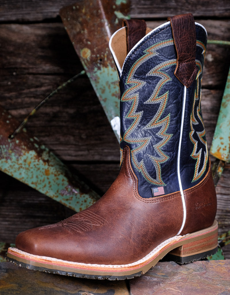 Brown and blue cowboy boot with intricate western stitching on a rustic wooden background