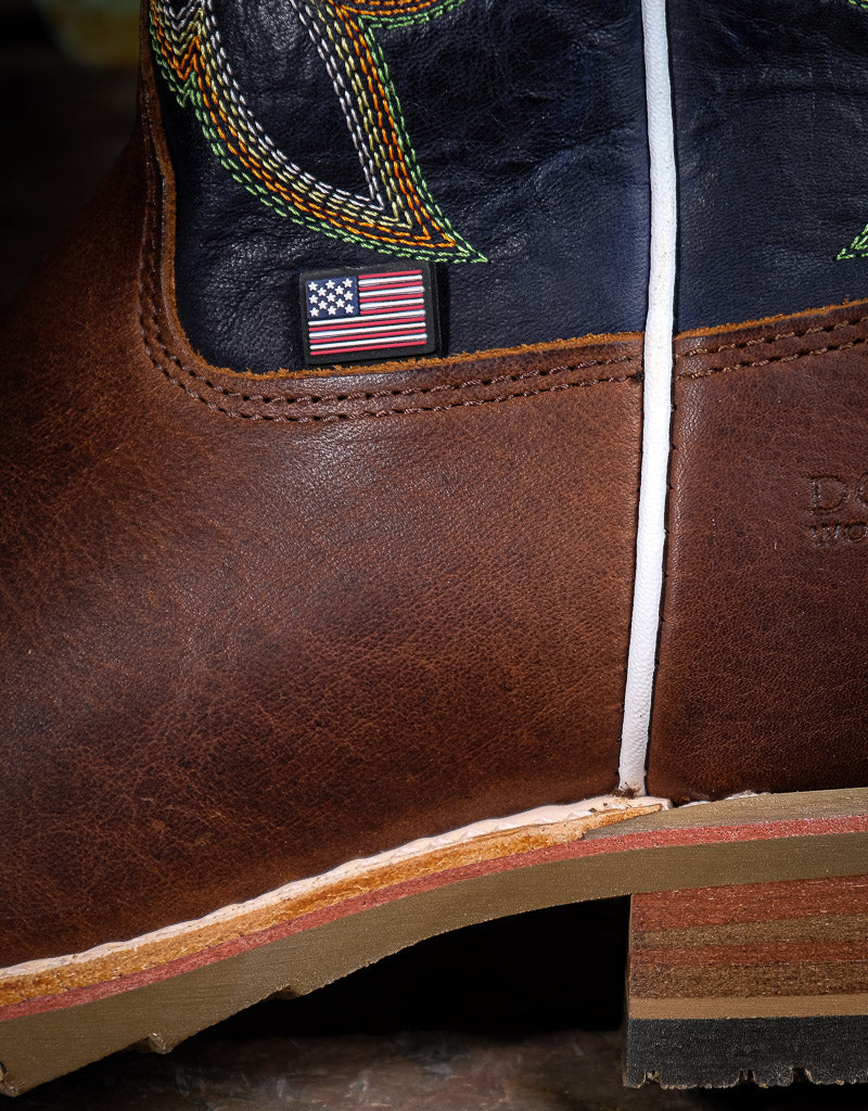 Close-up of a brown leather boot with an American flag label on a dark background