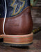 Close-up of a brown leather boot with 'Double H' branding on a rustic background